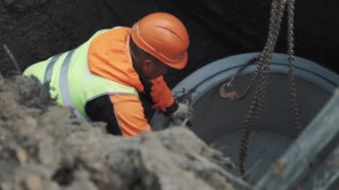 Saint Petersburg, Rusya - 26 Eylül 2016: İşçisi kask zincir yüzüğünü beton kuyu kirli açmada alarak