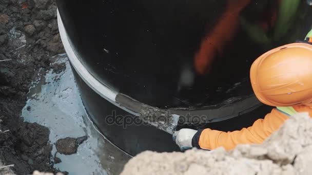 SAINT PETERSBURG, RUSSIE - 26 SEPTEMBRE 2016 : Assemblage entre deux anneaux de trou d'homme en béton avec couteau à mastic de ciment — Video