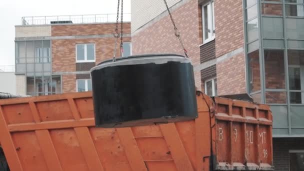 SAINT PETERSBURG, RÚSSIA - SETEMBRO 26, 2016: Caminhão de carro no local de construção com anel de bueiro de concreto balançando em cadeias — Vídeo de Stock