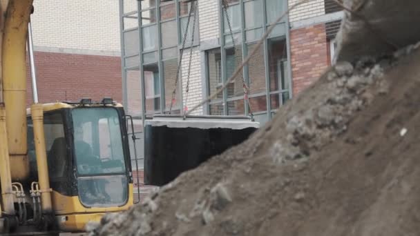 Saint petersburg, russland - 26. september 2016: bagger auf baustelle mit schwingendem beton-schachtring an ketten — Stockvideo