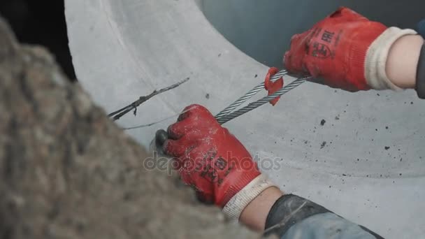 Saint petersburg, russland - 26. september 2016: arbeiter in rotem gummihandschuh löst metallschlinge aus beton im graben — Stockvideo