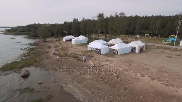 Sint-Petersburg, Rusland - 30 juli 2016: Luchtfoto shot mensen vliegen vliegers op wilde kust met witte tenten in de zomer — Stockvideo