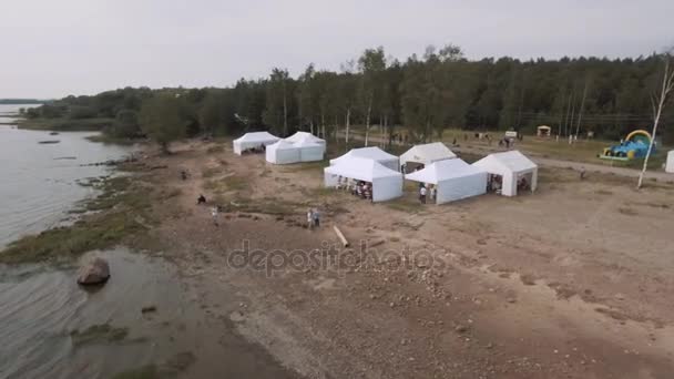 Saint Petersburg, Rusya - 30 Temmuz 2016: Hava atış insanlar uçmak uçurtma yaz beyaz çadır ile vahşi deniz kıyısında — Stok video