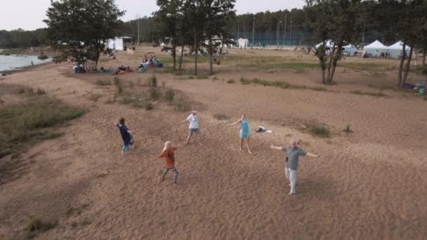 Petersburg, Rosja - 30 lipca 2016: Widok z lotu ptaka osób starszych robi ćwiczenia jogi, na piaszczystej plaży w okresie letnim — Wideo stockowe