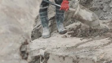İşçi kauçuk çimento yığın site oluşturma kürek kullanarak toplama botları