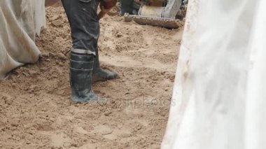 Hendek kuma yumuşatma kürek ile Slowmotion işçi lastik çizmeler