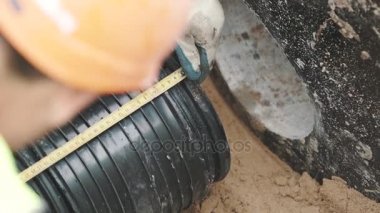 İşçiler baret ve siyah plastik boru bant-line cetvelle ölçme eldiven