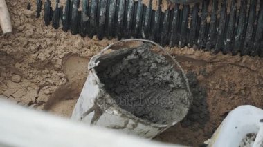 Kırmızı lastik eldiven işçi çimento kova al ve oluklu boru koy