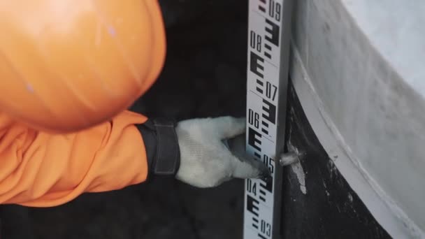Trabajador en naranja duro sombrero haciendo neasures con larga regla de metal industrial — Vídeo de stock
