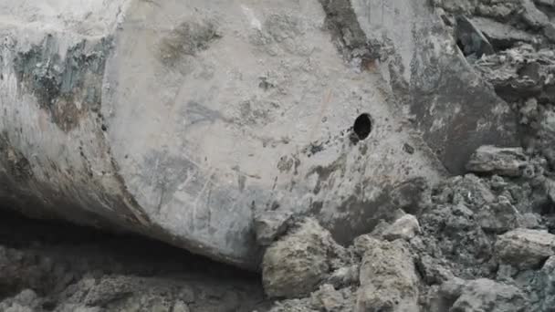 Seau d'excavatrice à mouvement lent creusant une grosse pile de terre et de saleté sur le chantier 