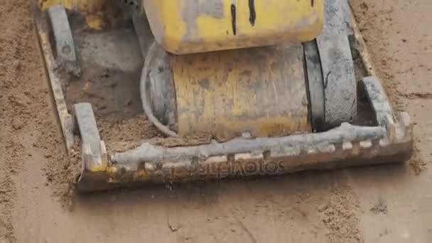 Compacteur à plaque jaune essence à mouvement lent épaississant la surface du sable — Video