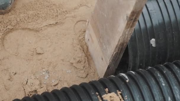 Slowmotion sledgehammer hitting piece of wood stuck to black plastic pipe — Stock Video