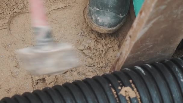 Slowmotion sledgehammer hitting piece of wood stuck between two plastic pipe — Stock Video