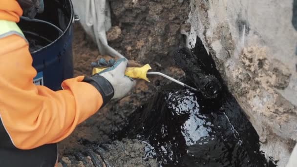 Bâtisseur main mettre goudron sur couture de ciment entre tuyau en plastique noir et béton — Video