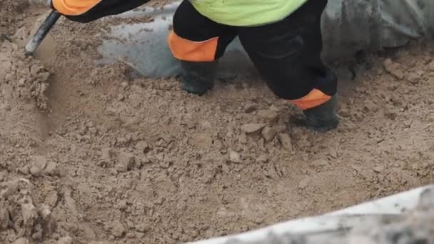 Builder digging pile of sand in ditch with shovel. Slowmotion — Stock Video