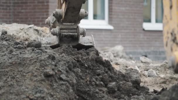 Baggerschaufel gräbt Erde Sand und Dreck auf Baustelle auf. Zeitlupe — Stockvideo