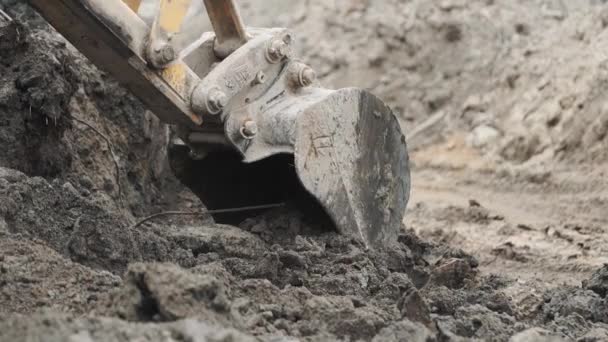 Escavadeira de pá cavando areia do solo e pilha de sujeira no local de construção. Movimento lento — Vídeo de Stock