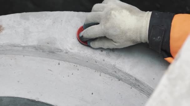 Hand in rotem Gummihandschuh Kunststoffstopfen in Betonstück im Graben — Stockvideo
