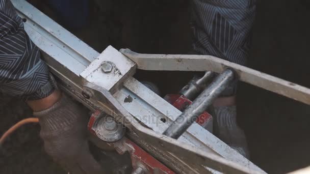 Llave giratoria de manos de trabajador en pieza de maquinaria industrial de metal en zanja — Vídeo de stock
