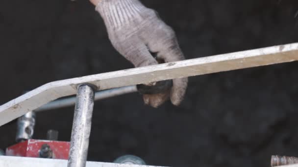 Mains de travailleurs tirant le levier sur un morceau de machine industrielle en métal dans un fossé — Video