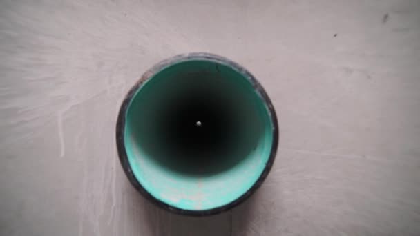 Ver a través de la vista de tubo de plástico negro y verde inmured en hormigón — Vídeo de stock