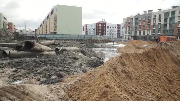 Dolly disparó montones de arena en el sitio de construcción. Trabajadores con palas — Vídeo de stock