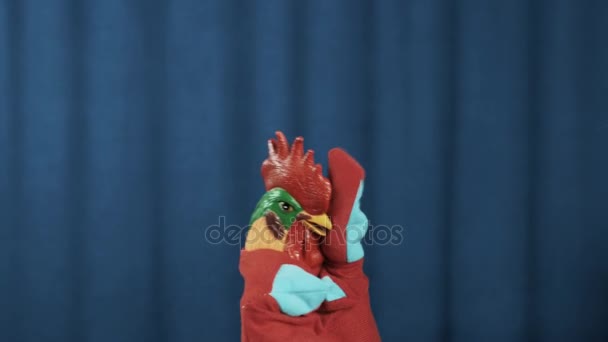Kohouta maňáska vytvořit obličej dlaněmi v nouzi na scéně s modrým pozadím