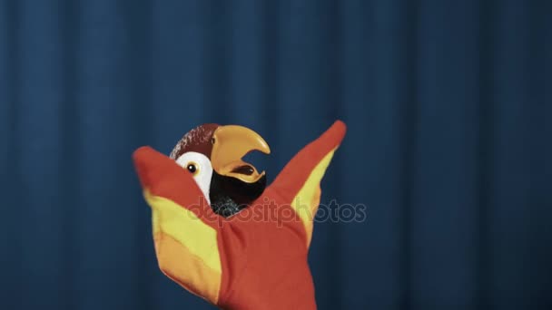 Papoušek maňáska třením a rozšířit ruce, mávali na modrém pozadí