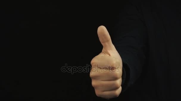 Male hand in long sleeve jacket pull thumb up, wiggle around on black backround — Stock Video