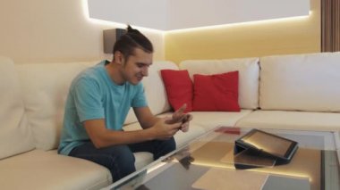 Neşeli adam olun smartphone, kısa yaşamak akarsu video sallayarak ve söz