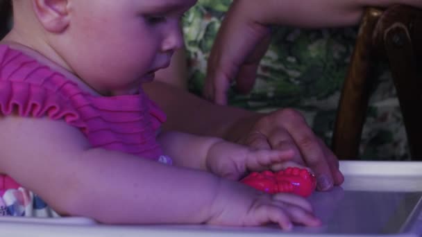 かわいい女の赤ちゃんを持つ母親がお祝いイベントのレストランでおもちゃで遊ぶ. — ストック動画