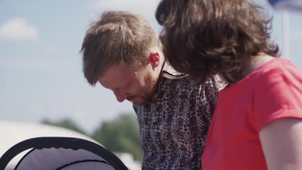 Les parents restent dans la rue avec bébé garçon mignon dans la voiture de bébé. La famille. Le bonheur — Video