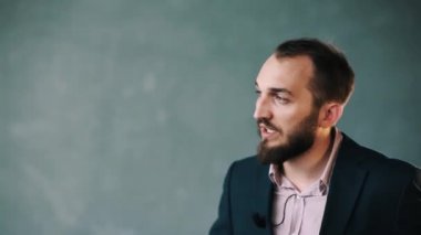 Ceket ve çizgili gömlekli sakallı adam güvenle izole duvara açıklar