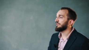 Ceket ve çizgili gömlekli sakallı adam güvenle sohbetçi çok hareketlerini kullanma