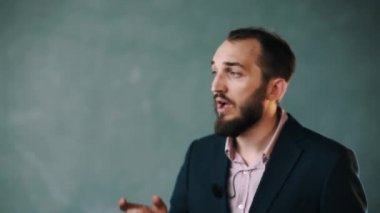 Ceket ve çizgili gömlekli sakallı adam hevesle hızlı el hareketleri ile görüşmeler