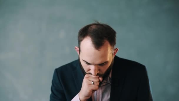 Bearded man in jacket and striped shirt cough into fist, rehearse speech — Stock Video