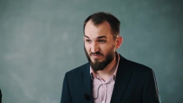 Ceket ve çizgili gömlekli sakallı adam yaka ve dinle soru ayarlar — Stok video