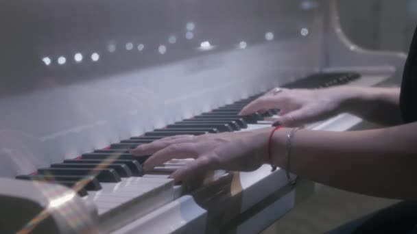 Female musician hands playing white piano at evening concert hall — Stock Video