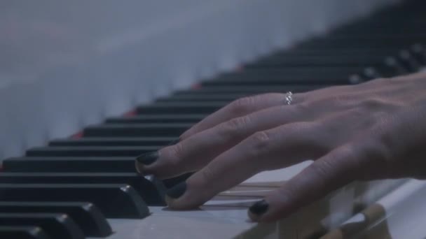 Braços femininos com anéis, esmalte preto e pulseira de corrente tocando piano — Vídeo de Stock