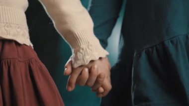 Küçük çocuklar kız arkadaşı elbiseler tutan eller üzerinde mavi arka plan