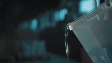 Başka bir kare plastik kova dışarı su dökme kauçuk eldiven erkek elinde