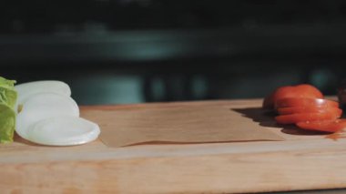 Erkek pişirme Şef beyaz elbise içinde pişmiş et ahşap kesme tahtası üzerinde koyar.