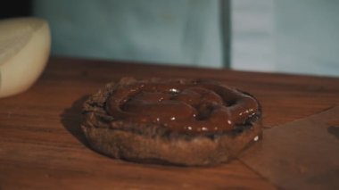 Hamburger yapma beyaz elbise içinde erkek pişirme Şef kesilerek domates çörek koyar.