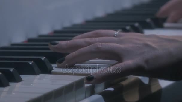 Mãos de músico feminino empurrando teclas de piano branco na sala de concertos à noite — Vídeo de Stock