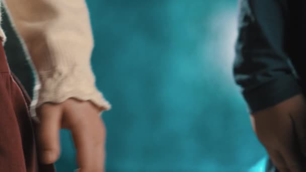 Kleine kinderen meisjes vrienden in jurken houdt handen op blauwe achtergrond — Stockvideo