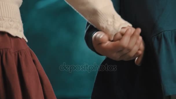 Little children girls couple in dresses holds hands on blue background — Stock Video