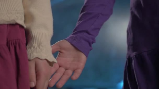 Pequeñas hermanas niños pareja en vestidos toma las manos sobre fondo azul — Vídeo de stock