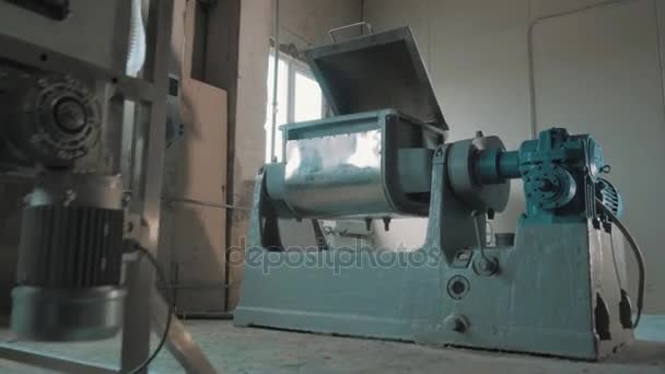 Mélange de sable à l'intérieur de la machine-outil avec couvercle ouvert dans une pièce d'usine lumineuse vide 