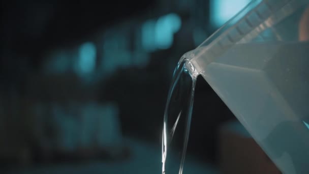Klares Wasser gießt langsam quadratischen transparenten Plastikeimer aus — Stockvideo