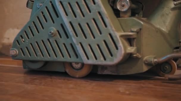 Sanding machine metal part raiding on top of new wooden parquet — Stock Video